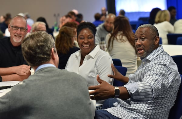 Melvin Kinard (right) talks to Mike Moss (foreground) as Stephen Gilkenson (left) and Corliss Kinard react during a "Grace and Race" seminar at Eagles Nest Church in Roswell on Saturday, May 6, 2017. HYOSUB SHIN / HSHIN@AJC.COM