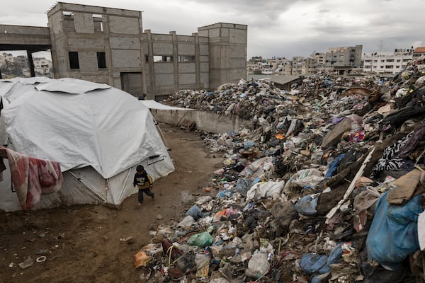 
                        A child passes between a tent where displaced Palestinian families have set up and a garbage dump in central Gaza City, on Friday, March 21, 2025. Israel’s defense minister said it was preparing to seize more territory in Gaza and intensify attacks unless Hamas freed more of the dozens of remaining captives. (Saher Alghorra/The New York Times)
                      