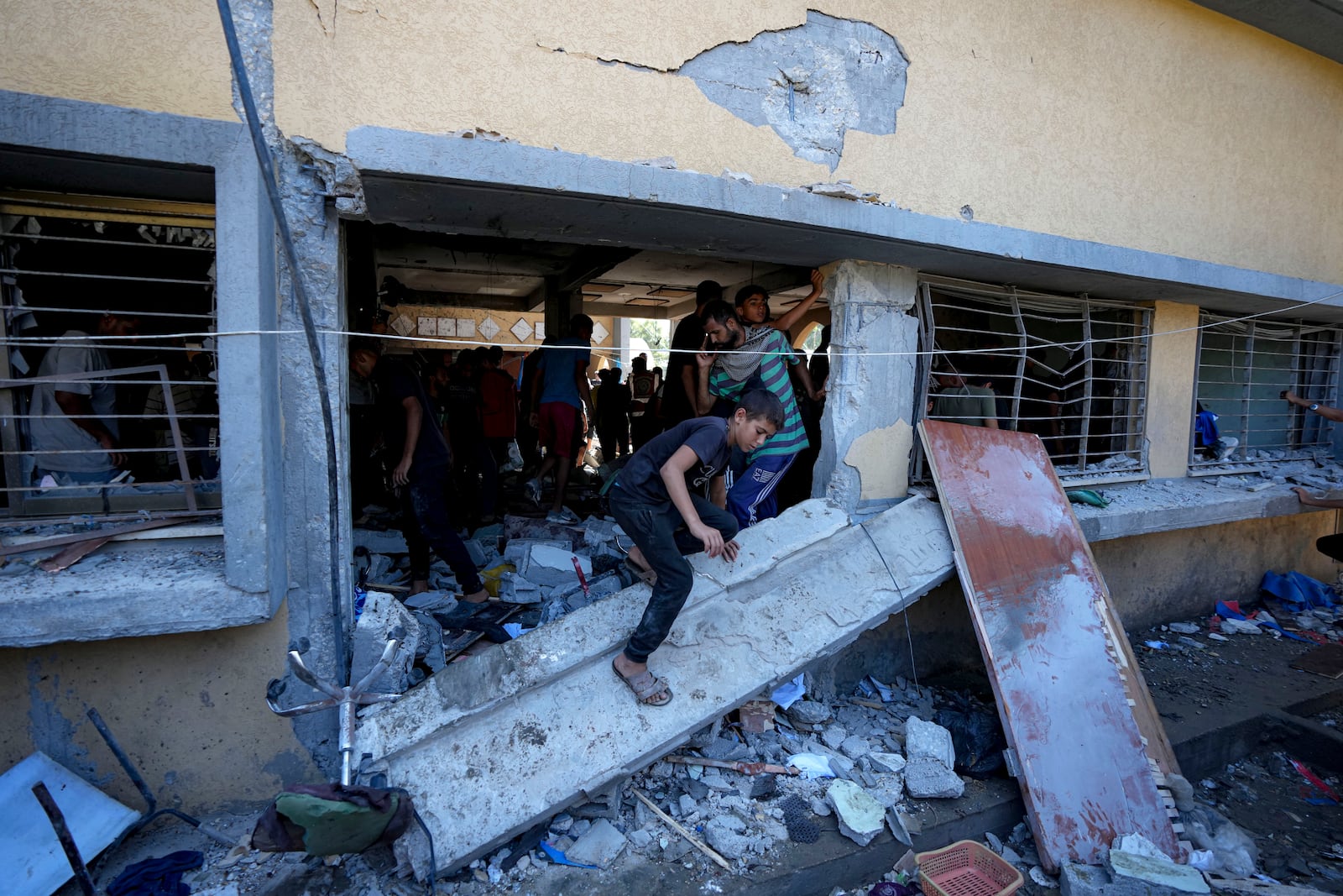 Palestinians search for the bodies of their relatives killed in an Israeli bombardment of a school in Deir al-Balah, central Gaza Strip, Thursday, Oct. 10, 2024. (AP Photo/Abdel Kareem Hana)