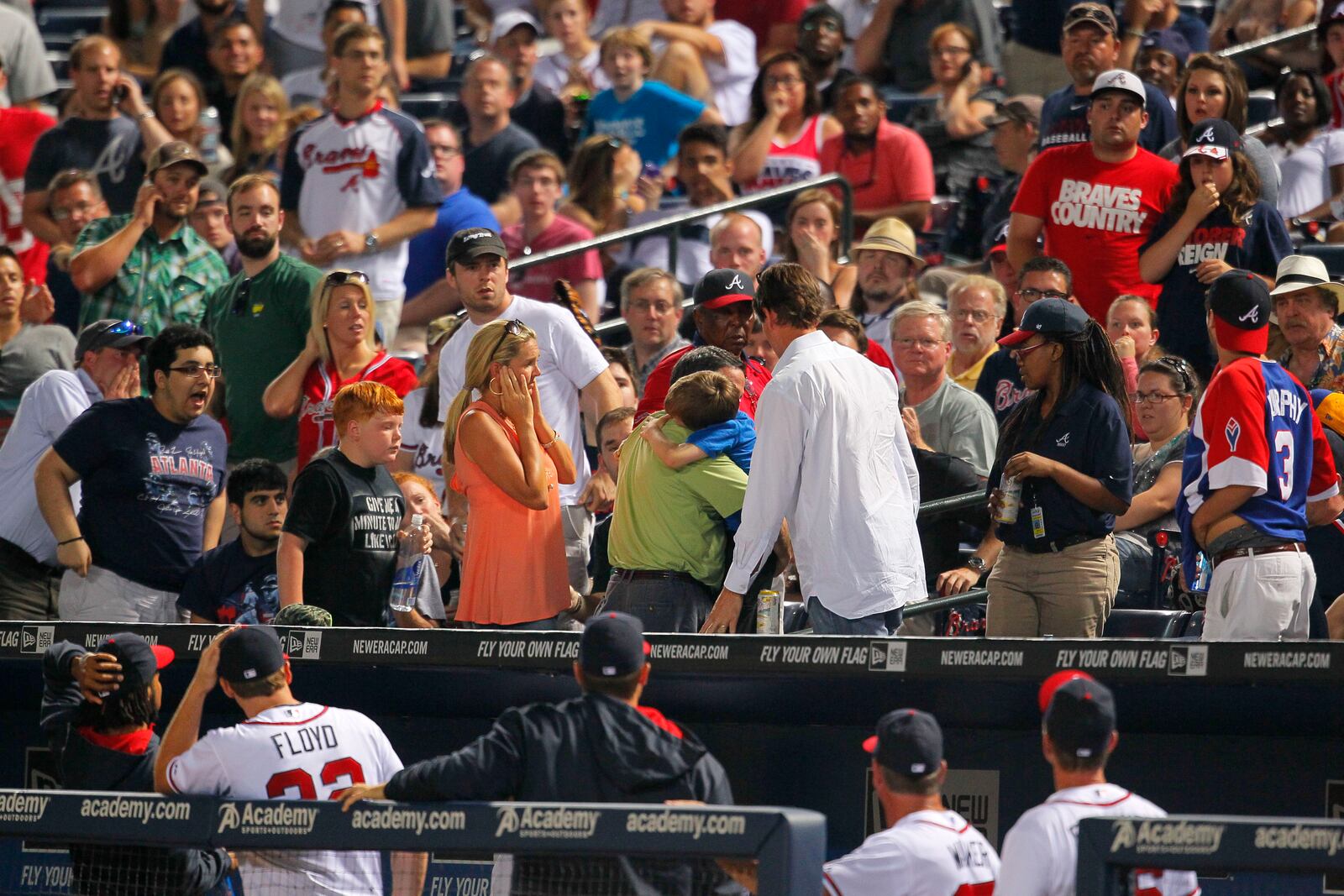 An 8-year-old boy is picked up by his father and rushed up the steps after being hit by a foul ball during a 2014 Atlanta Braves game at Turner Field. (AP Photo/Todd Kirkland)