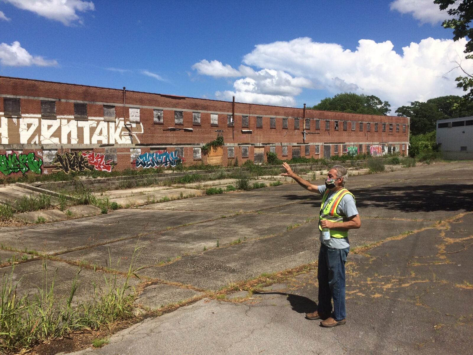 Southwest Atlanta resident Matt Garbett points out an old canning factory in the abandoned 20-acre parcel of old brick industrial buildings called Murphy Crossing. (Photo by Bill Torpy)