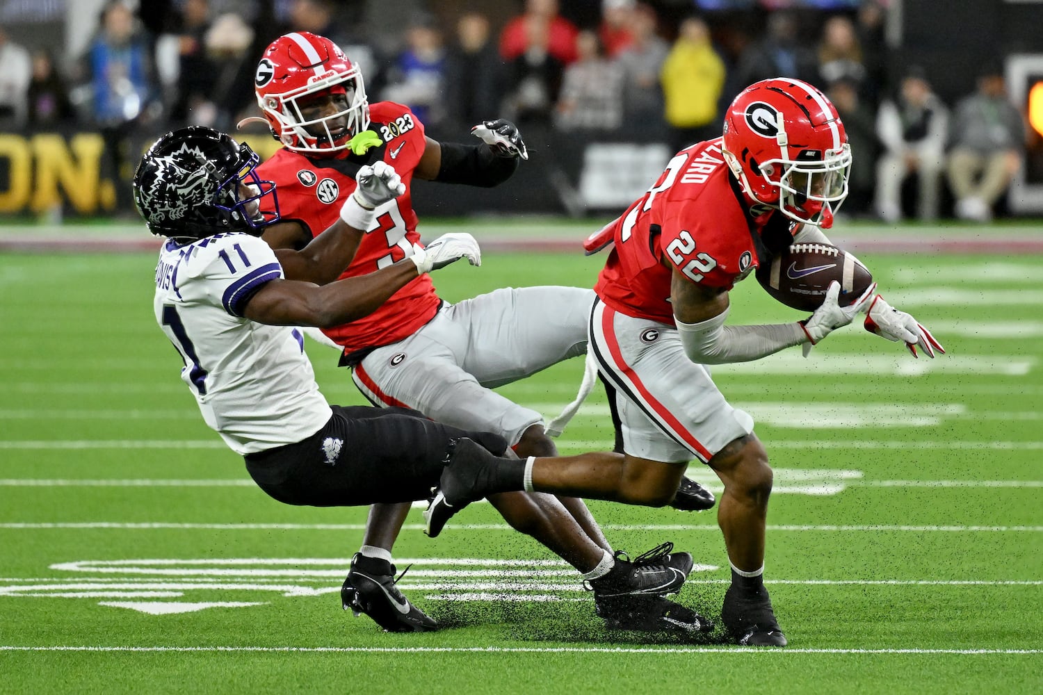 Georgia Bulldogs defensive back Javon Bullard (22) intercepts a pass intended for TCU Horned Frogs wide receiver Derius Davis (11) as Bulldogs defensive back Kamari Lassiter (3) backs him up during the first half of the College Football Playoff National Championship at SoFi Stadium in Los Angeles on Monday, January 9, 2023. (Hyosub Shin / Hyosub.Shin@ajc.com)