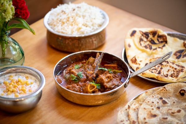 Chai Pani Kolhapuri Mutton with slow-cooked bone-in goat in a gravy of roasted coconut, red chiles, onion, and curry leaves with aged basmati rice, veg raita, and assorted breads. (Mia Yakel for The Atlanta Journal-Constitution)