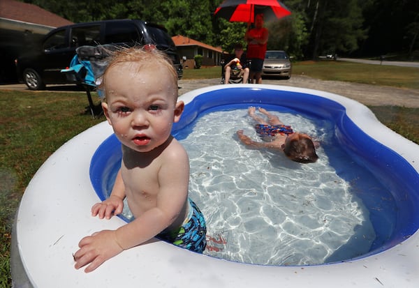 Bradley Murchison, 1, and his brother George, 6, try to beat the heat while visiting their great-grandmother Joyce Webb for the Memorial Day 2019 holiday weekend in College Park.