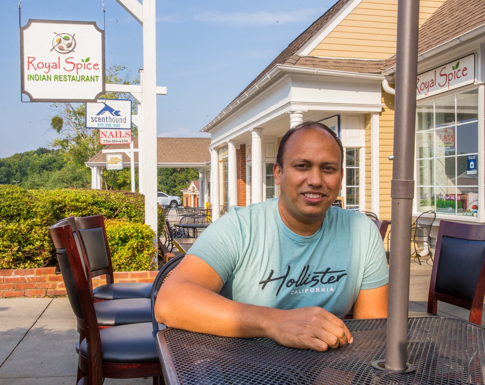 Dunwoody Village businesses, including Royal Spice, may soon have a new city center, in the mean time the locals enjoy whatever green space and outdoor patios they can find in the multiple shopping complexes patched together in the area on Thursday, July 22, 2021.  Junayed Ahmed owns Royal Spice and just celebrated their first year June 1; part of his concern is visibility with shrubbery, recessed store fronts and the outdated signage, which makes it easy to pass by. (Jenni Girtman for The Atlanta Journal-Constitution)