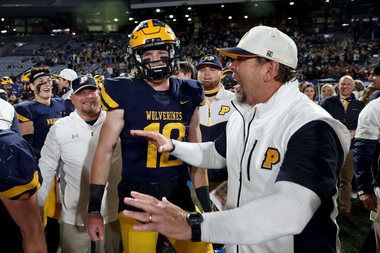 Prince Avenue Christian coach Greg Vandagriff, right, celebrates with his son and quarterback Brock Vandagriff (12) after their 41-21 win against Trinity Christian during the Class 1A Private championship at Center Parc Stadium Monday, December 28, 2020 in Atlanta, Ga.. JASON GETZ FOR THE ATLANTA JOURNAL-CONSTITUTION