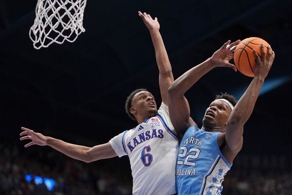 North Carolina forward Ven-Allen Lubin (22) shoots under pressure from Kansas guard Rylan Griffen (6) during the second half of an NCAA college basketball game Friday, Nov. 8, 2024, in Lawrence, Kan. Kansas won 92-89. (AP Photo/Charlie Riedel)