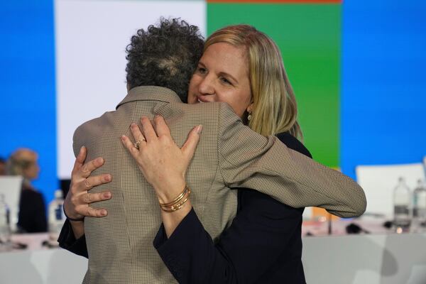 Kirsty Coventry, right, is embraced by Anita Defrantz after she was announced as the new IOC President at the International Olympic Committee 144th session in Costa Navarino, western Greece, Thursday, March 20, 2025. (AP Photo/Thanassis Stavrakis)