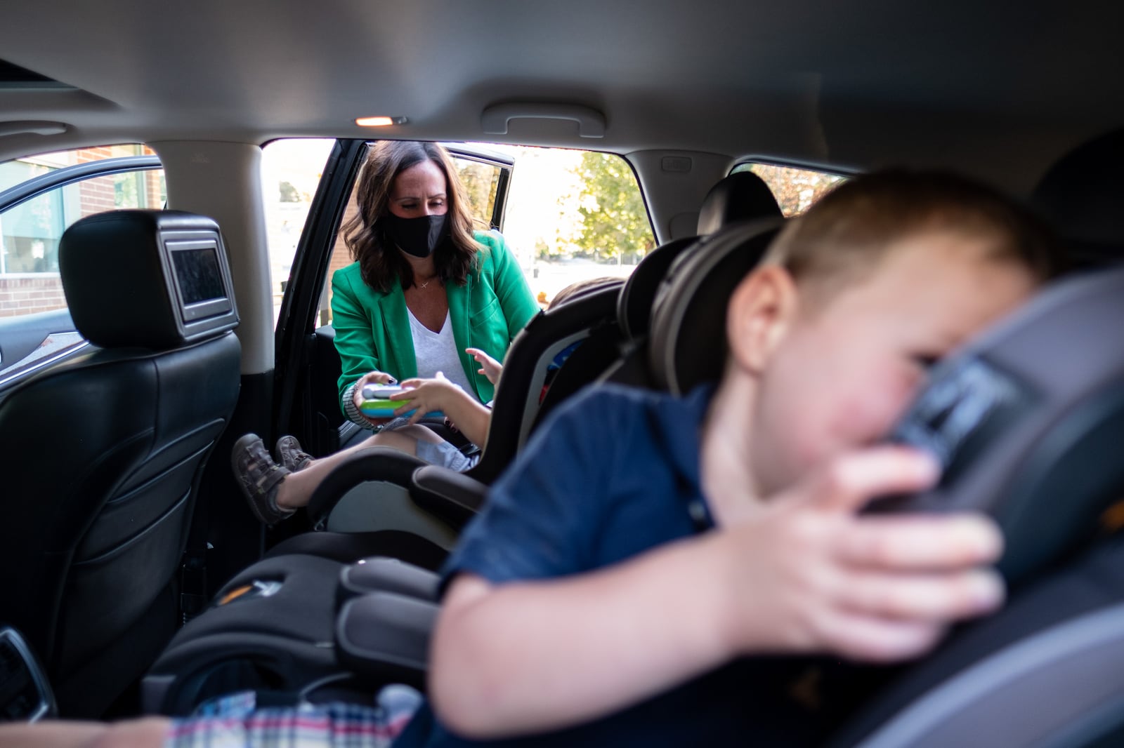 201014-Sandy Springs-Kim Sanders picks up her sons Eli, 2, and Rex, 3, from The Goddard School of Sandy Springs on Wednesday afternoon, October 14, 2020. Sanders, who also has a 6-year-old daughter, said there is no way she could work as an accounting consultant without a school for the kids to go to. Normally she would go to her sons’ classrooms to pick them up, but the COVID-19 safety measures include a staff member bringing children to the lobby and only one family is allowed in at a time. Ben Gray for The Atlanta Journal-Constitution