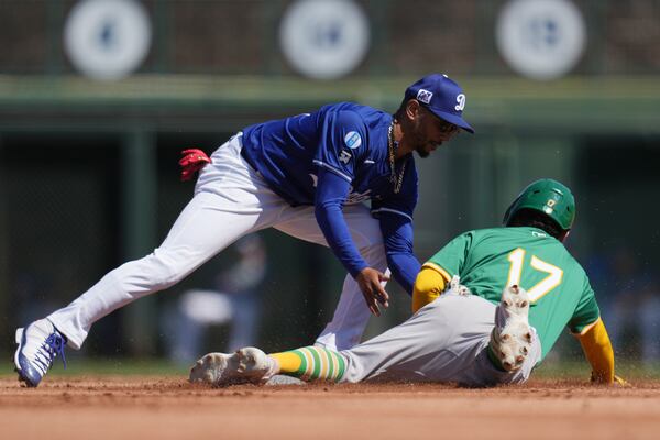 Los Angeles Dodgers shortstop Mookie Betts, left, tags out Athletics' Luis Urías (17) attempting to steal second base during the second inning of a spring training baseball game Sunday, March 9, 2025, in Phoenix. (AP Photo/Ross D. Franklin)