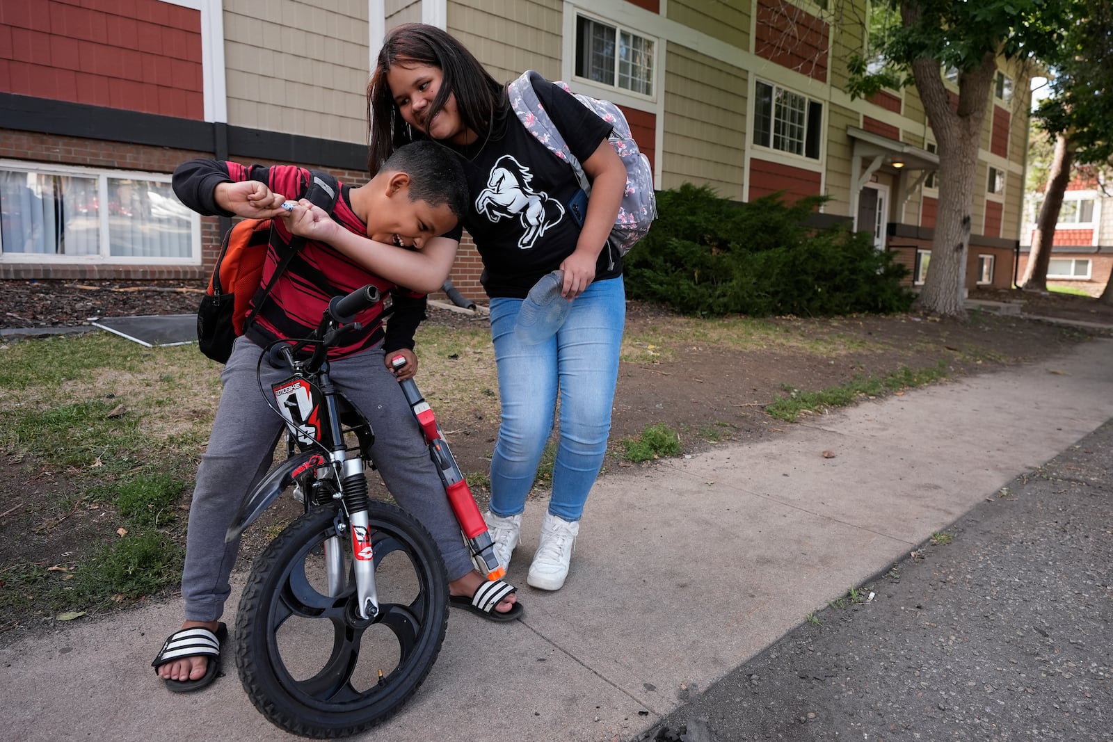 Alisson, right, plays with her nephew Dylan outside their apartment Thursday, Aug. 29, 2024, in Aurora, Colo. (AP Photo/Godofredo A. Vásquez)