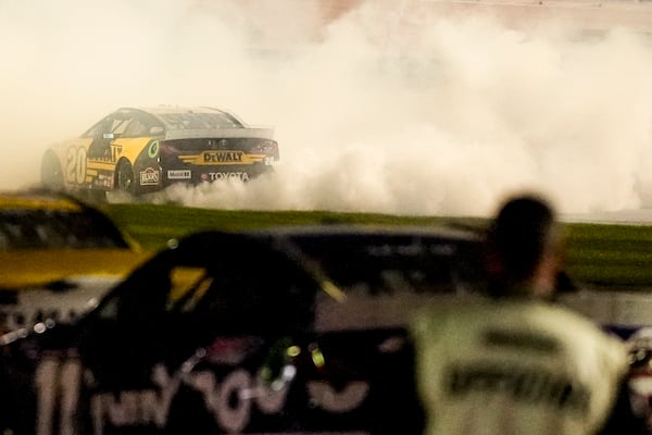 Christopher Bell celebrates victory after a NASCAR Cup Series auto race, Sunday, Feb. 23, 2025, in Hampton, Ga. (AP Photo/Mike Stewart)