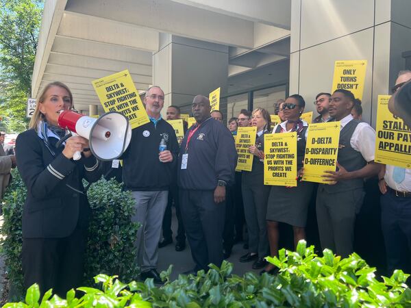 Association of Flight Attendants International President Sara Nelson speaks into a megaphone at a rally in downtown Atlanta as United Auto Workers President Shawn Fain holds a sign up next to her. Kelly Yamanouchi / kelly.yamanouchi@ajc.com