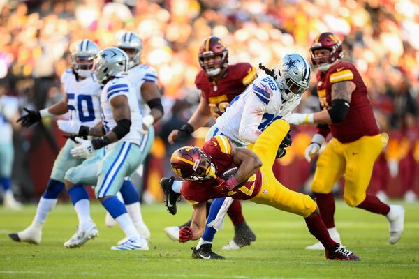 Washington Commanders running back Jeremy McNichols (26) is tackled by Dallas Cowboys safety Malik Hooker (28) during the second half of an NFL football game, Sunday, Nov. 24, 2024, in Landover, Md. (AP Photo/Nick Wass)