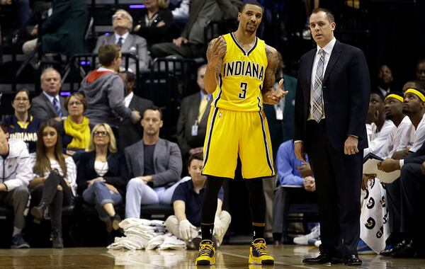 Indiana Pacers head coach Frank Vogel, right, talks with guard George Hill (3) as free throws are being shot during the second half of an NBA basketball game against the Oklahoma City Thunder in Indianapolis, Sunday, April 12, 2015. The Pacers won 116-104. (AP Photo/AJ Mast) Indiana Pacers head coach Frank Vogel (right) talks strategy with guard George Hill. The Hawks swept the Pacers (3-0) this season. (Al Mast / AP)