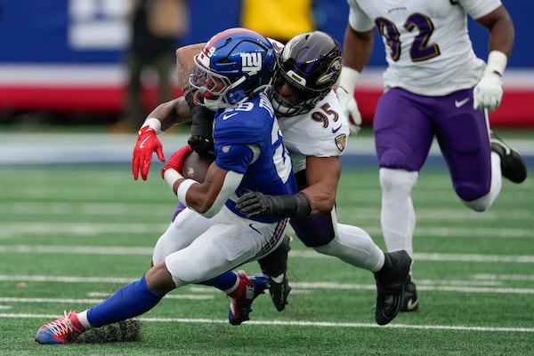 New York Giants running back Tyrone Tracy Jr. (29) is tackled by Baltimore Ravens linebacker Tavius Robinson (95) during the second quarter of an NFL football game, Sunday, Dec. 15, 2024, in East Rutherford, N.J. (AP Photo/Seth Wenig)