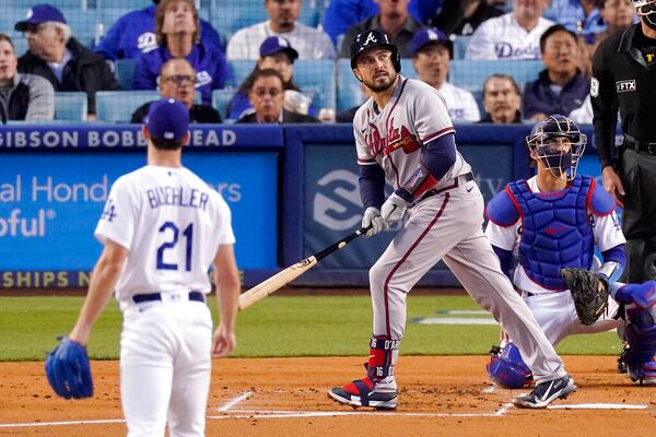 Atlanta Braves' Travis d'Arnaud, center, heads toward first after hitting a solo home run as Los Angeles Dodgers starting pitcher Walker Buehler, left, and catcher Austin Barnes watch during the second inning of a baseball game Tuesday, April 19, 2022, in Los Angeles. (AP Photo/Mark J. Terrill)