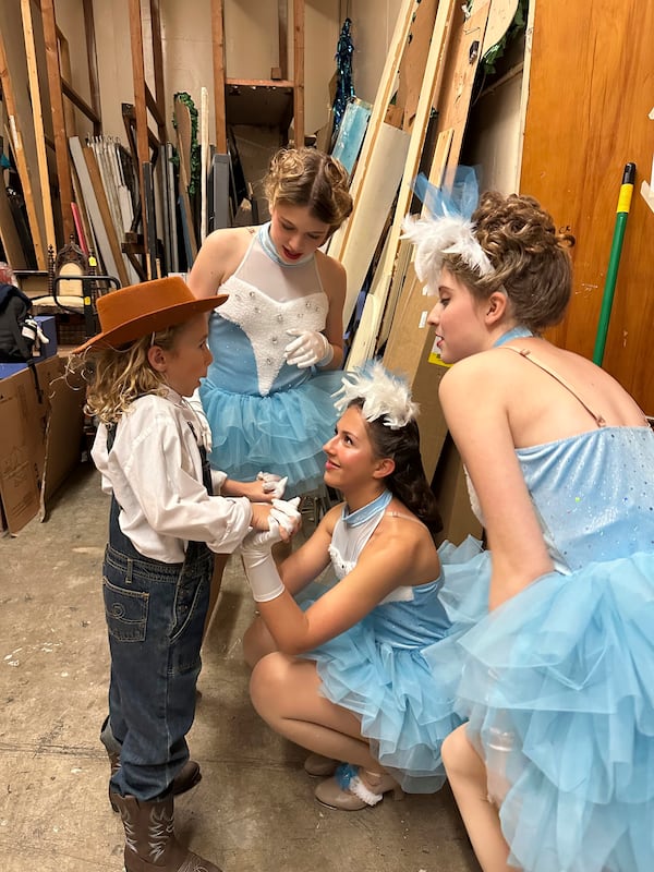 Amelie Barragan, 14, kneeling at center, and fellow cast members from Theatre Palisades Youth give a pre-show pep talk to Kiki Moncher, 8, left, on opening night of Crazy for You just weeks after losing their theater in the Palisades fire, Los Angeles, Calif., Feb. 28, 2025. (AP Photo/Jocelyn Gecker)