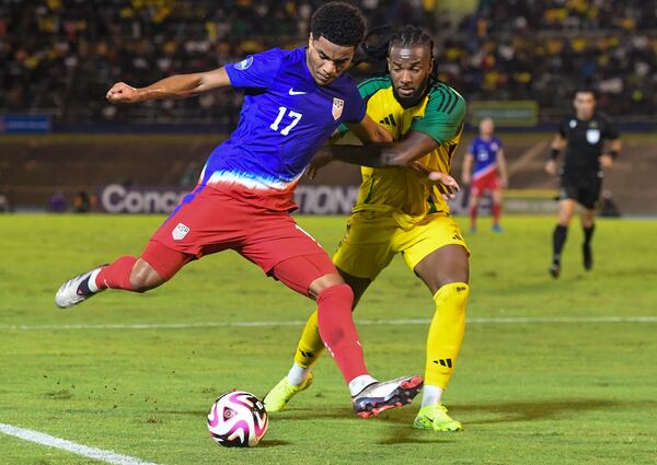 United States' Malik Tillman, left, fights for the ball against Jamaica's Kasey Palmer during a CONCACAF Nations League quarterfinal first leg soccer match in Kingston, Jamaica, Thursday, Nov. 14, 2024. (AP Photo/Collin Reid)