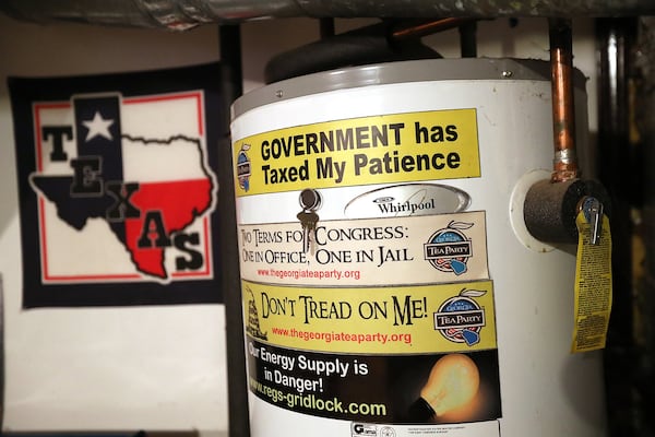 West’s water heat is covered with political bumper stickers at his home in Kennesaw. Curtis Compton/ccompton@ajc.com