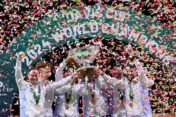 Italian tennis team members hold the Davis Cup trophy after the final between Netherlands and Italy at the Martin Carpena Sports Hall in Malaga, southern Spain, as Italy wins its second consecutive Davis Cup title, Sunday, Nov. 24, 2024. (AP Photo/Manu Fernandez)