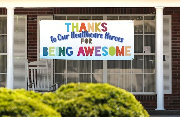 A banner hangs on the front porch of Windermere Health and Rehabilitation Center in Augusta. As of Thursday, the nursing home has had 76 residents with confirmed cases of COVID-19, where residents have had 75 positive cases of COVID-19 and six deaths. The home also has 33 staff members who have been infected. Curtis Compton ccompton@ajc.com