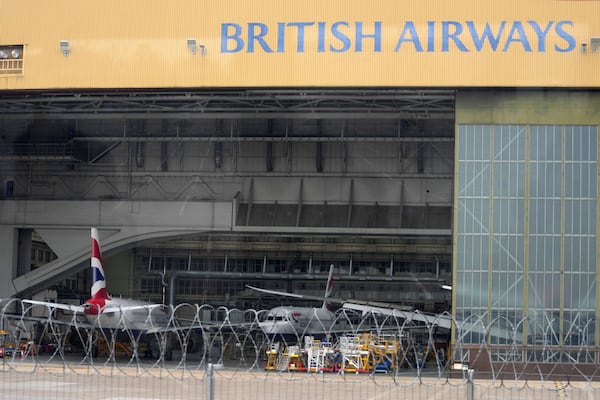 British Airways planes are sitting in a hangar as Britain's Heathrow Airport has closed for the full day Friday after an electrical substation fire knocked out its power, disrupting flights for hundreds of thousands of passengers at one of Europe's biggest travel hubs in London, Friday, March 21, 2025.(AP Photo/Kin Cheung)