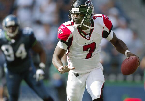 Falcons quarterback Michael Vick looks for a receiver while scrambling under pressure from Seattle Seahawks’ Bryce Fisher (94) during the second quarter in Seattle Sunday, Sept. 18, 2005. (AP Photo/John Froschauer)