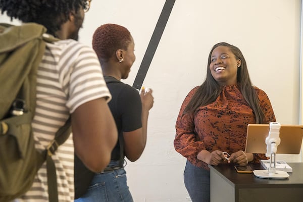 Amanda Williamson (right), CEO of Ennyluap, speaks with potential customers during a “Pop-Up Row” shopping event along Mitchell Street in Atlanta’s South Downtown community. (ALYSSA POINTER/ALYSSA.POINTER@AJC.COM)