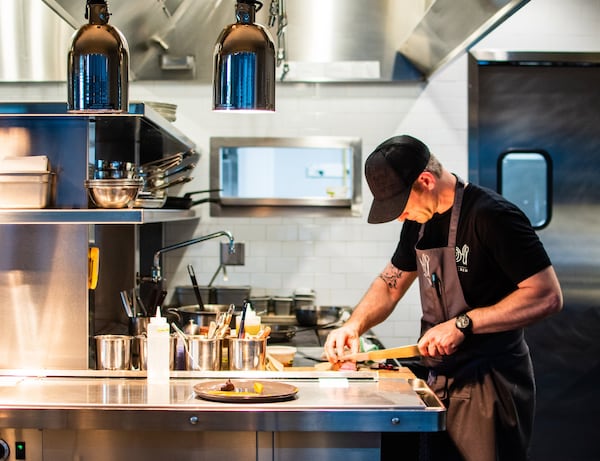 Chef Jared Hucks slices a steak in the kitchen of the Alden in Chamblee. CONTRIBUTED BY HENRI HOLLIS