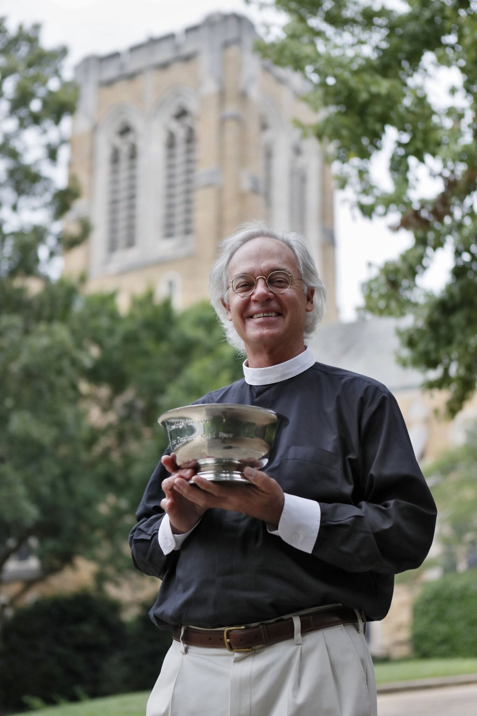 In a tradition for a couple of decades, the Rev. Sam Candler of the Cathedral of St. Philip blesses AJC Peachtree Road Race runners with holy water. He’s doing the invocation at the start of this year’s race. BOB ANDRES / BANDRES@AJC.COM