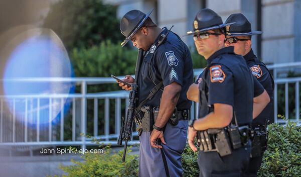 Capitol police keep civilians back as bomb techs search the car of a protesting veteran who set himself on fire. JOHN SPINK / JSPINK@AJC.COM