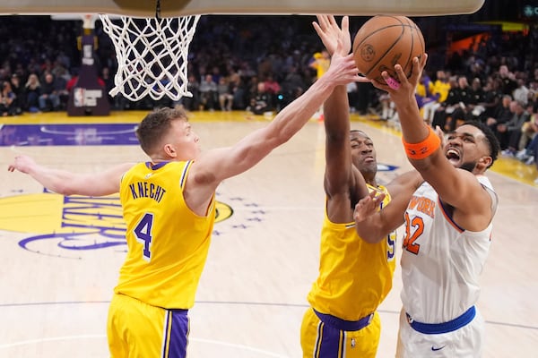 New York Knicks center Karl-Anthony Towns, right, shoots as Los Angeles Lakers guard Dalton Knecht, left, and center Trey Jemison III defend during the first half of an NBA basketball game Thursday, March 6, 2025, in Los Angeles. (AP Photo/Mark J. Terrill)