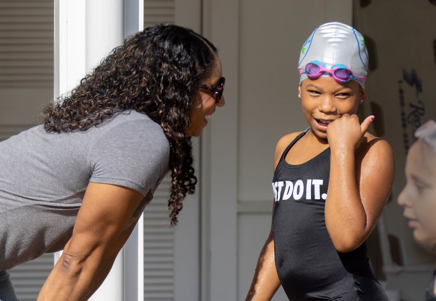 Maritza Correia Mcclendon (left), an Olympic medalist who now promotes swimming for blacks and hispanics, talks with her daughter, Sanaya, 8, after her race in a swim meet at Leslie Beach Club in Atlanta on Saturday, May 21, 2022.   (Bob Andres / robert.andres@ajc.com)