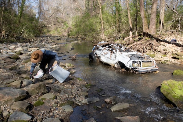 Volunteer Rhett Rutherford bagged trash along Proctor Creek during Sweep The Hooch day in Atlanta in March of 2021. Proctor Creek runs through Atlanta and ultimately empties into the Chattahoochee River. STEVE SCHAEFER FOR THE ATLANTA JOURNAL-CONSTITUTION