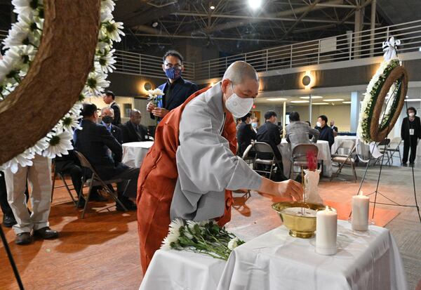 March 16, 2022 Norcross - A monk participates in dedication of flowers ceremony during the Commemoration of the March 16 Atlanta Shooting at Korean American Center in Nocross on Wednesday, March 16, 2022. (Hyosub Shin / Hyosub.Shin@ajc.com)