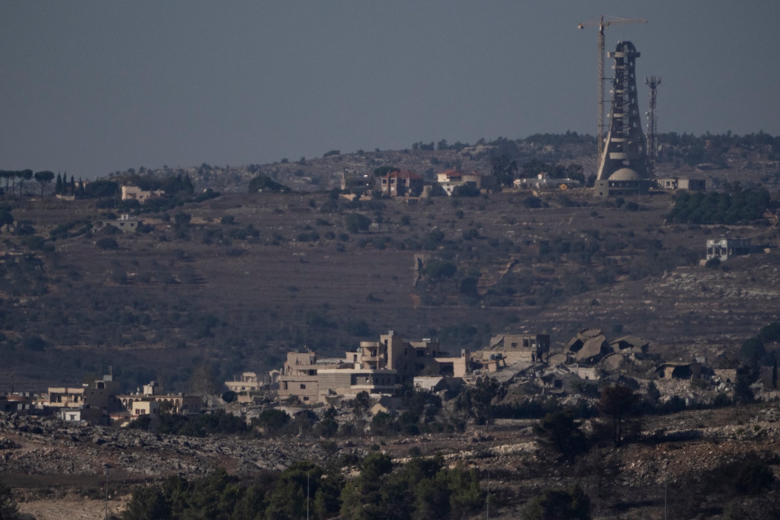 Destroyed buildings stand in an area in southern Lebanon as seen from northern Israel, Tuesday, Oct. 8, 2024. (AP Photo/Leo Correa)