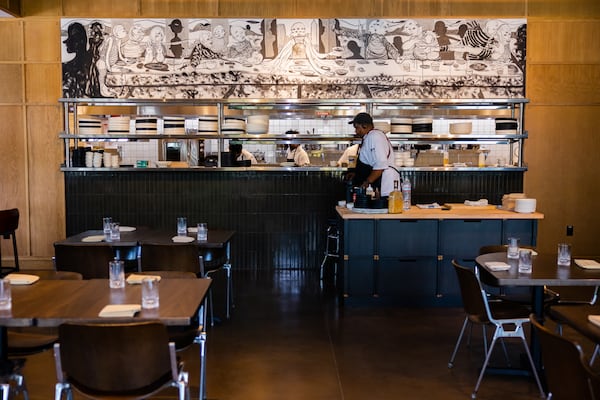 Duane Nutter stands in front of the partially open kitchen at Southern National. The artwork above the kitchen is by local artist William Downs. Courtesy of Rebecca Carmen