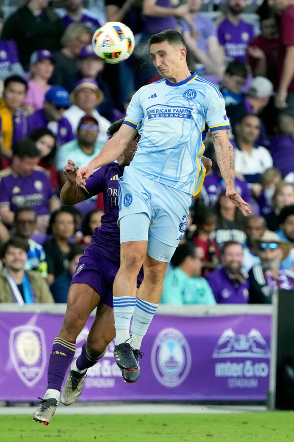 Orlando City's Ramiro Enrique, left, and Atlanta United's Bartosz Slisz go up for a head ball during the second half of an MLS Semifinal Conference playoff soccer match, Sunday, Nov. 24, 2024, in Orlando, Fla. (AP Photo/John Raoux)