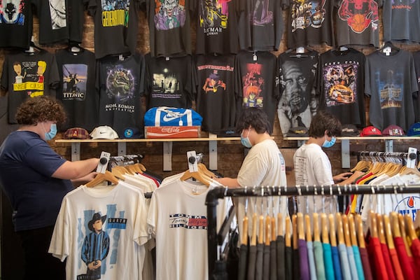 Customers at Drugstore Atlanta, a vintage clothing shop, wear masks as they look through racks of clothing at the store in Little Five Points. (Alyssa Pointer/Atlanta Journal Constitution)