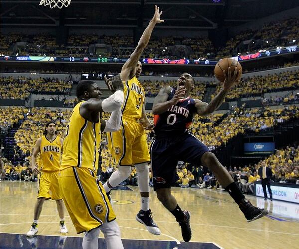 Jeff Teague, de los Hawks de Atlanta, salta para disparar frente a Roy Hibbert y George Hill (3), de los Pacers de Indiana, en el partido de playoffs disputado el sábado 19 de abril de 2014 (AP Foto/Darron Cummings) Jeff Teague scored 28 points. The Pacers were not please. (Darron Cummings/AP)