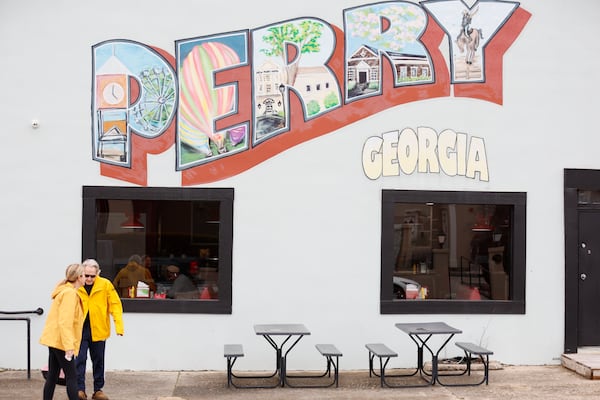 A couple of people are seen crossing Jernigan St beside the popular Sweet P's in downtown Perry, Ga, on Thursday, February 13, 2025. The diverse array of businesses and shops is remarkable, showcasing the continual revival of this historic downtown area.
(Miguel Martinez/ AJC)