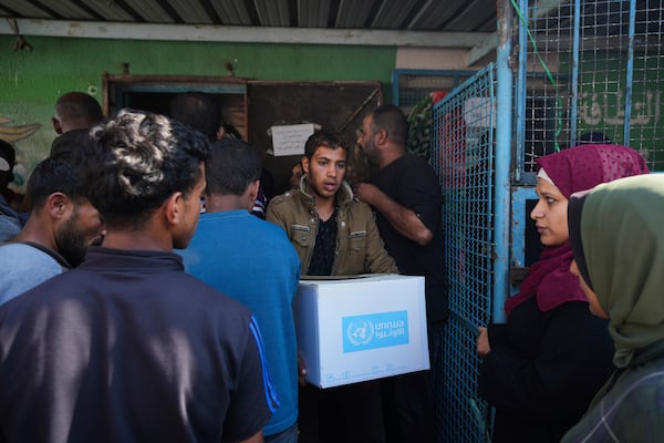 Palestinians receive aid distributed by UNRWA, the U.N. agency helping Palestinian refugees, in Nusairat refugee camp, Gaza, Tuesday, Nov. 5, 2024. (AP Photo/Abdel Kareem Hana)