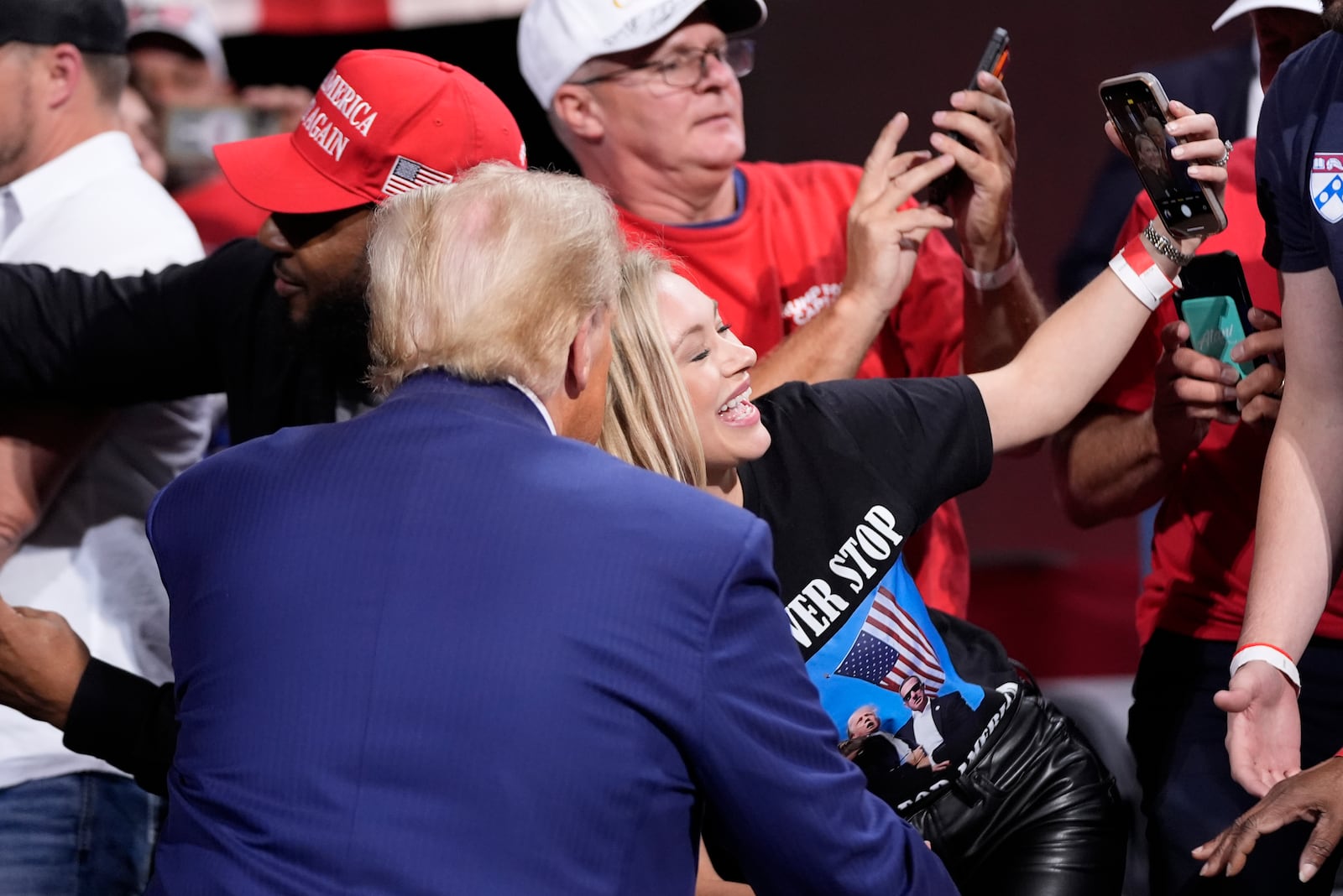 Republican presidential nominee former President Donald Trump poses for a photo with a supporter at a campaign event at the Cobb Energy Performing Arts Centre, Tuesday, Oct. 15, 2024, in Atlanta. (AP Photo/Alex Brandon)