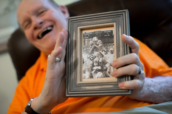 Walter Chadwick, who was a star running back at the University of Tennessee in the 1960s, holds a photo of him scoring a touchdown during a game against Tulane University. Chadwick was named head coach of Wills High School in 1971, but after being on the job just two weeks, an accident left Chadwick brain-damaged. Chadwick recently gathered with friends and former students, many of whom thought he was dead. BRANDEN CAMP / SPECIAL