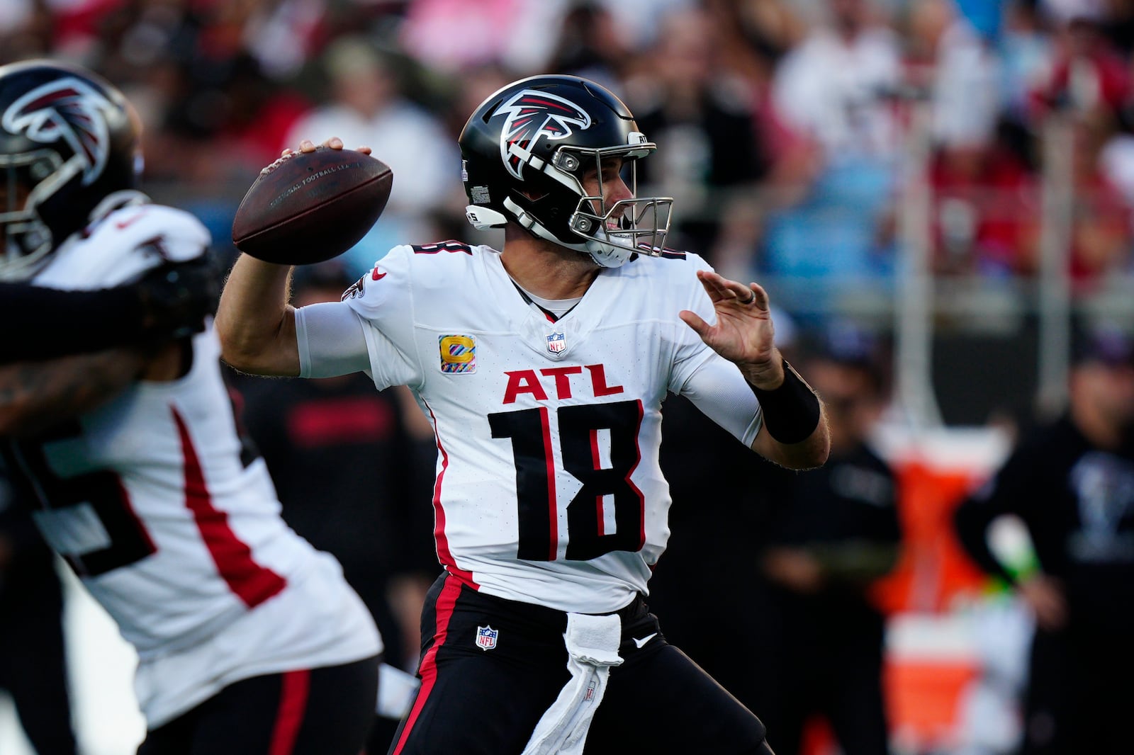 Atlanta Falcons quarterback Kirk Cousins (18) looks to pass the ball in the first half of an NFL football game against the Carolina Panthers in Charlotte, N.C., Sunday, Oct. 13, 2024. (AP Photo/Jacob Kupferman)