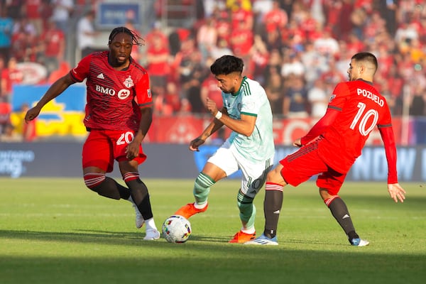 Atlanta United midfielder Marcelino Moreno, center, takes the ball between Toronto FC forward Ayo Akinola and midfielder Alejandro Pozuelo, right, during the first half of an MLS soccer match Saturday, June 25, 2022, in Toronto. (Chris Young/The Canadian Press via AP)