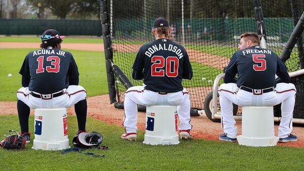 Braves players Ronald Acuna (from left), Josh Donaldson, and Freddie Freeman use empty baseball buckets to sit on while waiting their turn to bat during the first full squad workout at spring training in the ESPN Wide World of Sports Complex on Thursday, Feb. 21, 2019, in Lake Buena Vista.    Curtis Compton/ccompton@ajc.com