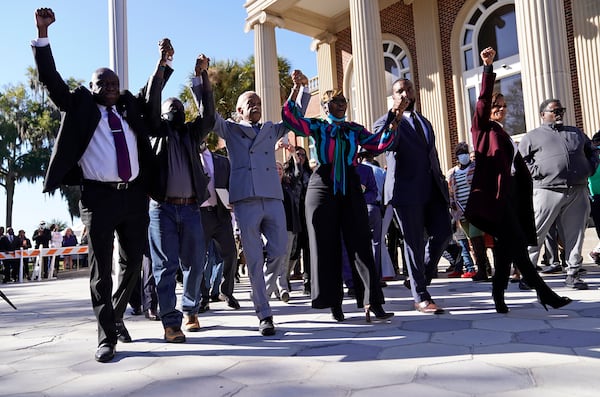 The Rev. Al Sharpton (third from left) holds hands with Ahmaud Arbery’s parents, Wanda Cooper-Jones and Marcus Arbery, as they react outside the Glynn County Courthouse in Brunswick after the jury found three men guilty of murder. (Nicole Craine/The New York Times 2021)