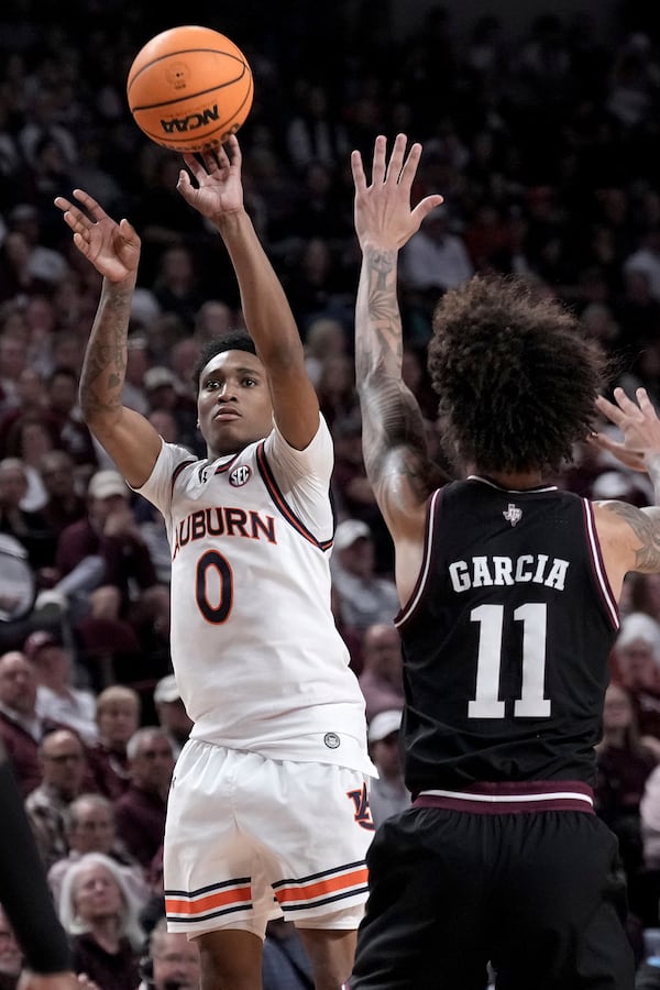 Auburn guard Tahaad Pettiford (0) makes a three point basket over Texas A&M forward Andersson Garcia (11) during the second half of an NCAA college basketball game Tuesday, March 4, 2025, in College Station, Texas. (AP Photo/Sam Craft)